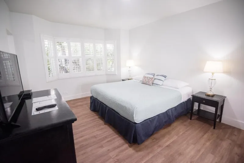 Deluxe room with desk and television facing the queen bed
