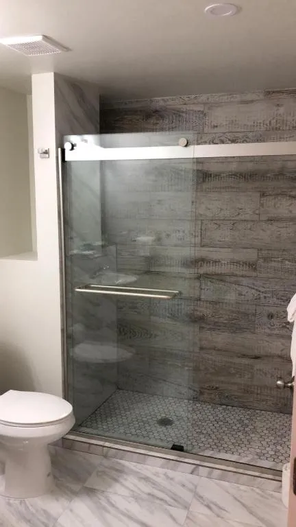 Glass-door shower in the Deluxe room’s private bathroom