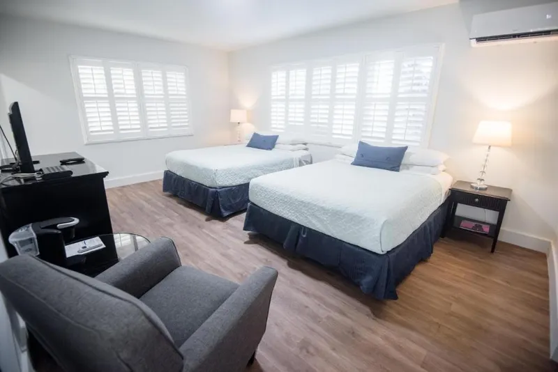 Double Queen room with bedside tables and window shutters